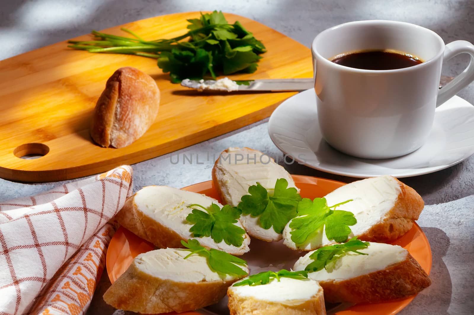 Freshly made sandwiches with cream cheese and parsley on a plate, chopping wooden board and a cup of coffee - morning and breakfast concept by galsand