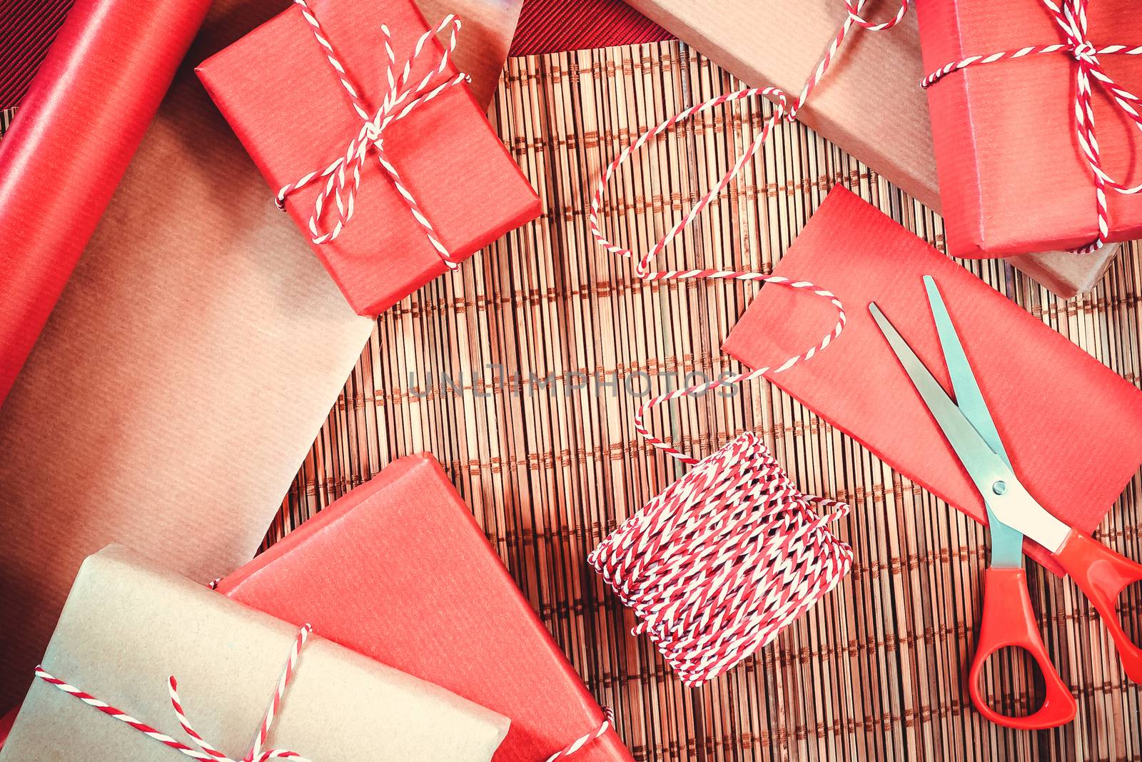 Preparing for the holiday - gift wrapping in red and beige wrapping paper.