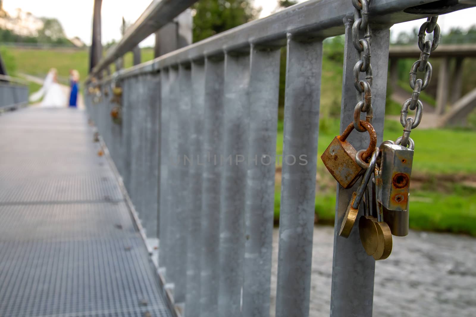Different ages padlocks on the metal bridge in Latvia. Wedding tradition. Rusty locks on the bridge hanging chain.