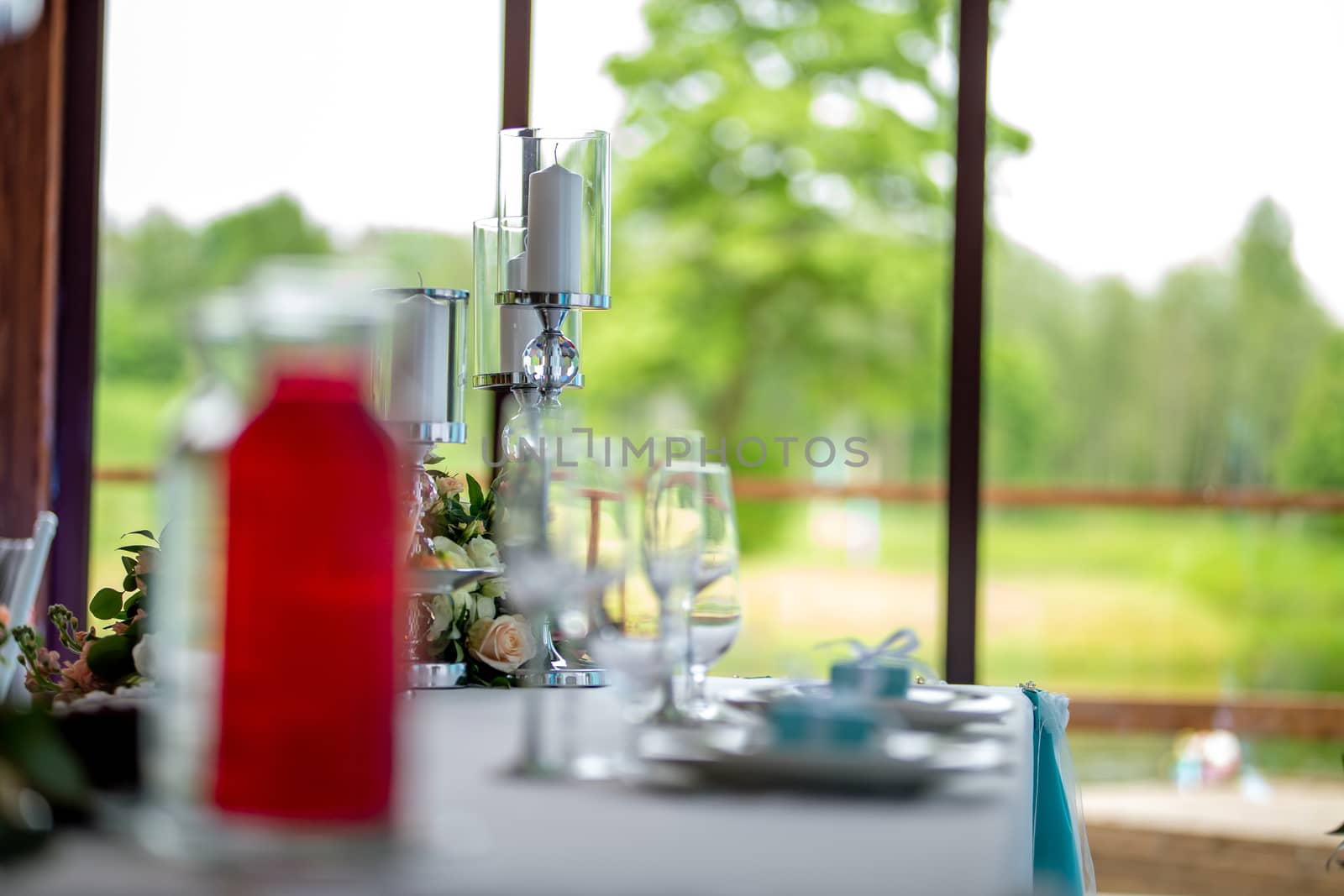 Candles and dishes on the festive table by fotorobs