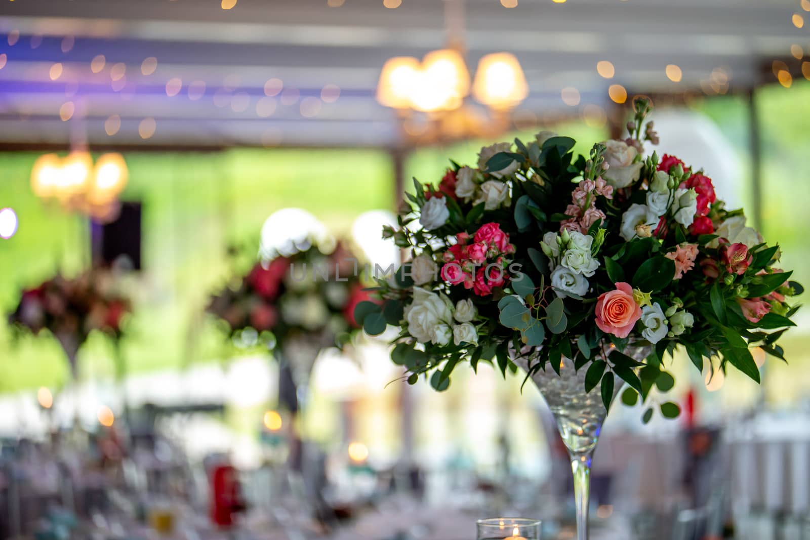 Wedding table decoration. Beautiful bouquet of flowers in vase on the table. Bouquet of flowers, setting on the festive table in restaurant.