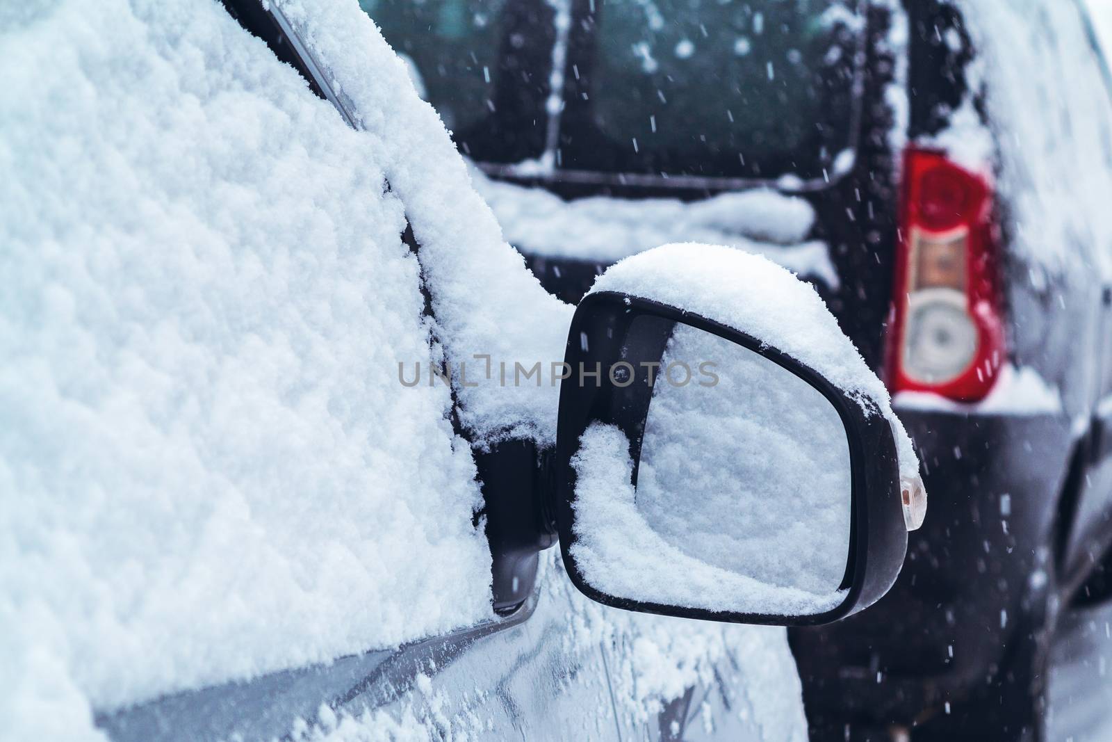 Snowfall in the city, part of the car covered by snow by galsand