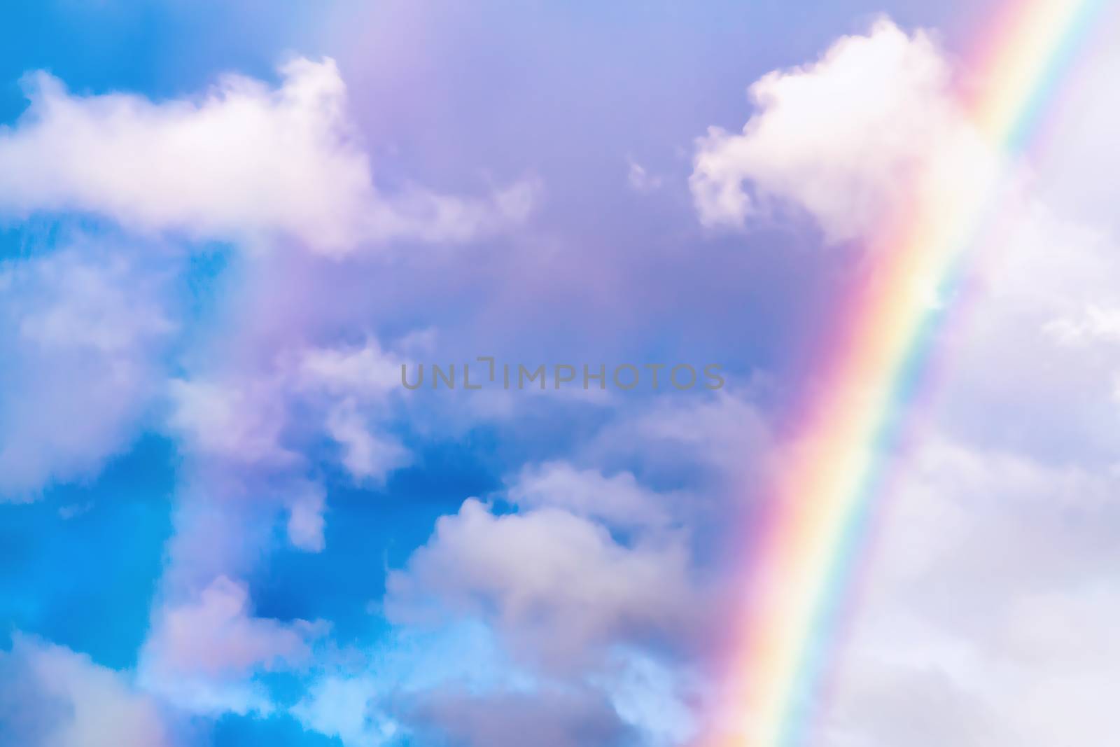 Rainbow after rain in a cloudy sky among clouds.