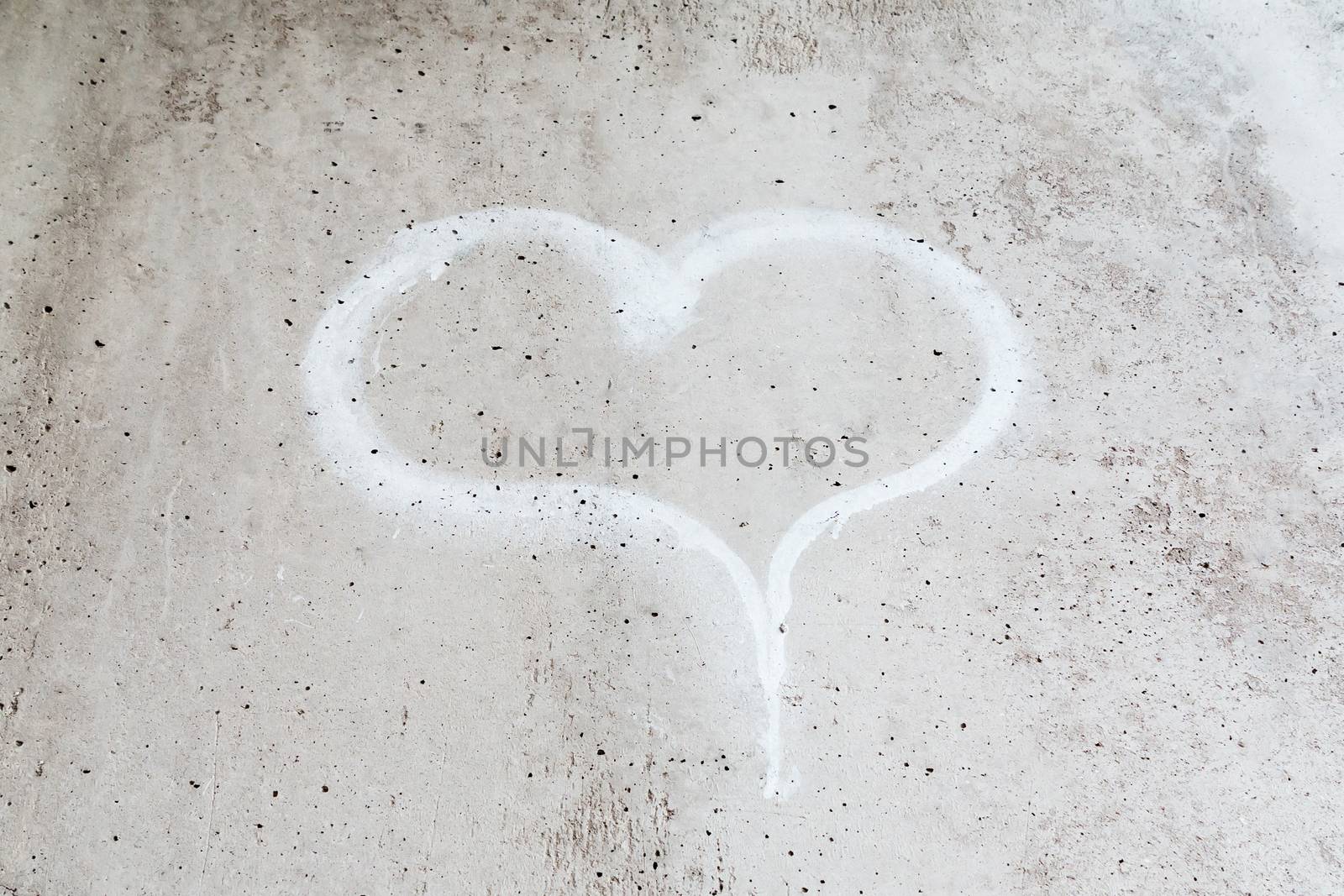 Heart drawn in chalk on a gray concrete wall by galsand