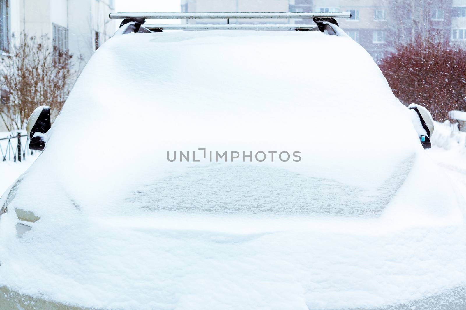 Snowfall, view of the snow-covered car in front.