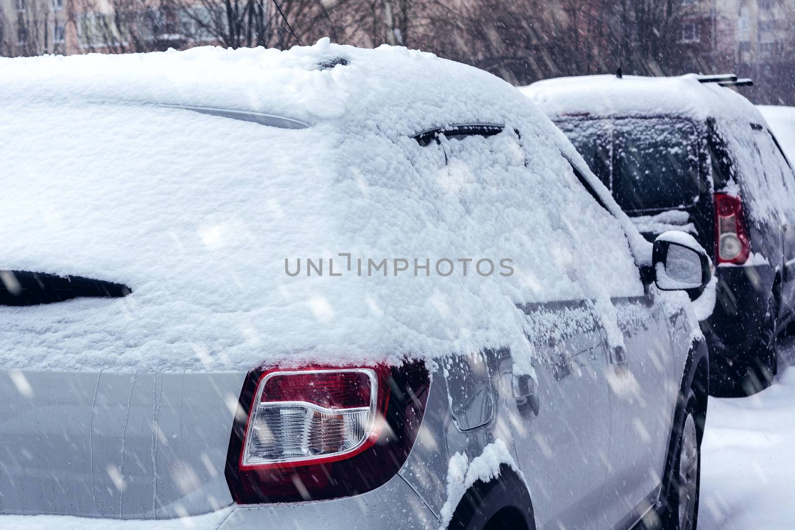 Snowfall in the city, cars overwhelmed with snow by galsand