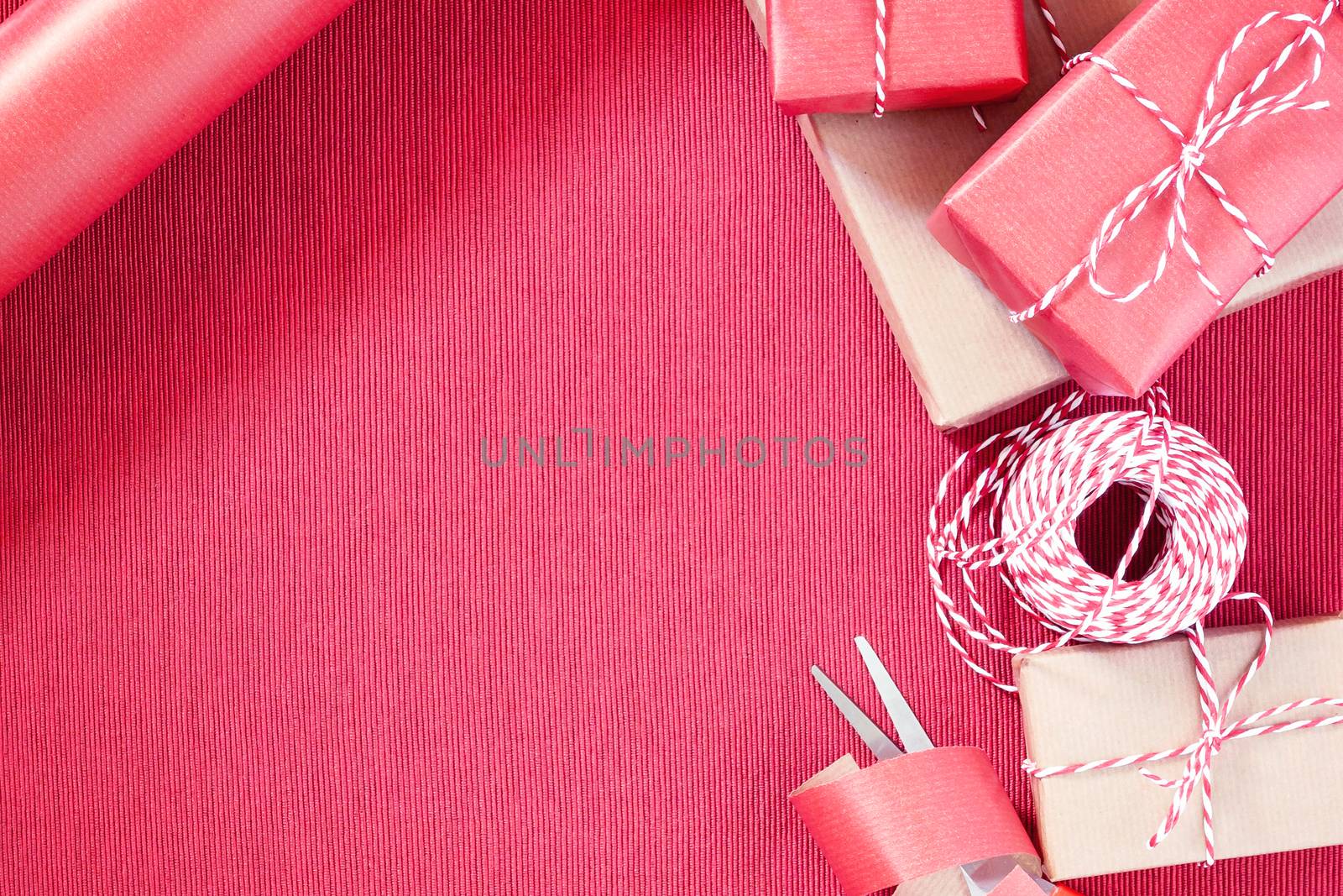 Preparing for the holiday - gift wrapping in red and beige wrapping paper.