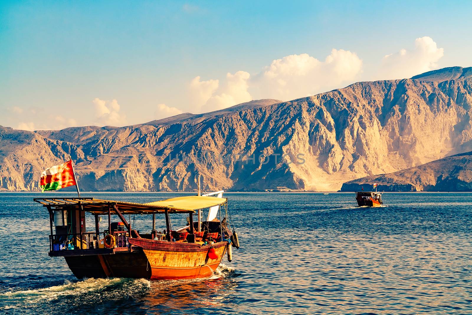 Sea, pleasure boats, rocky shores in the fjords of the Gulf of Oman.