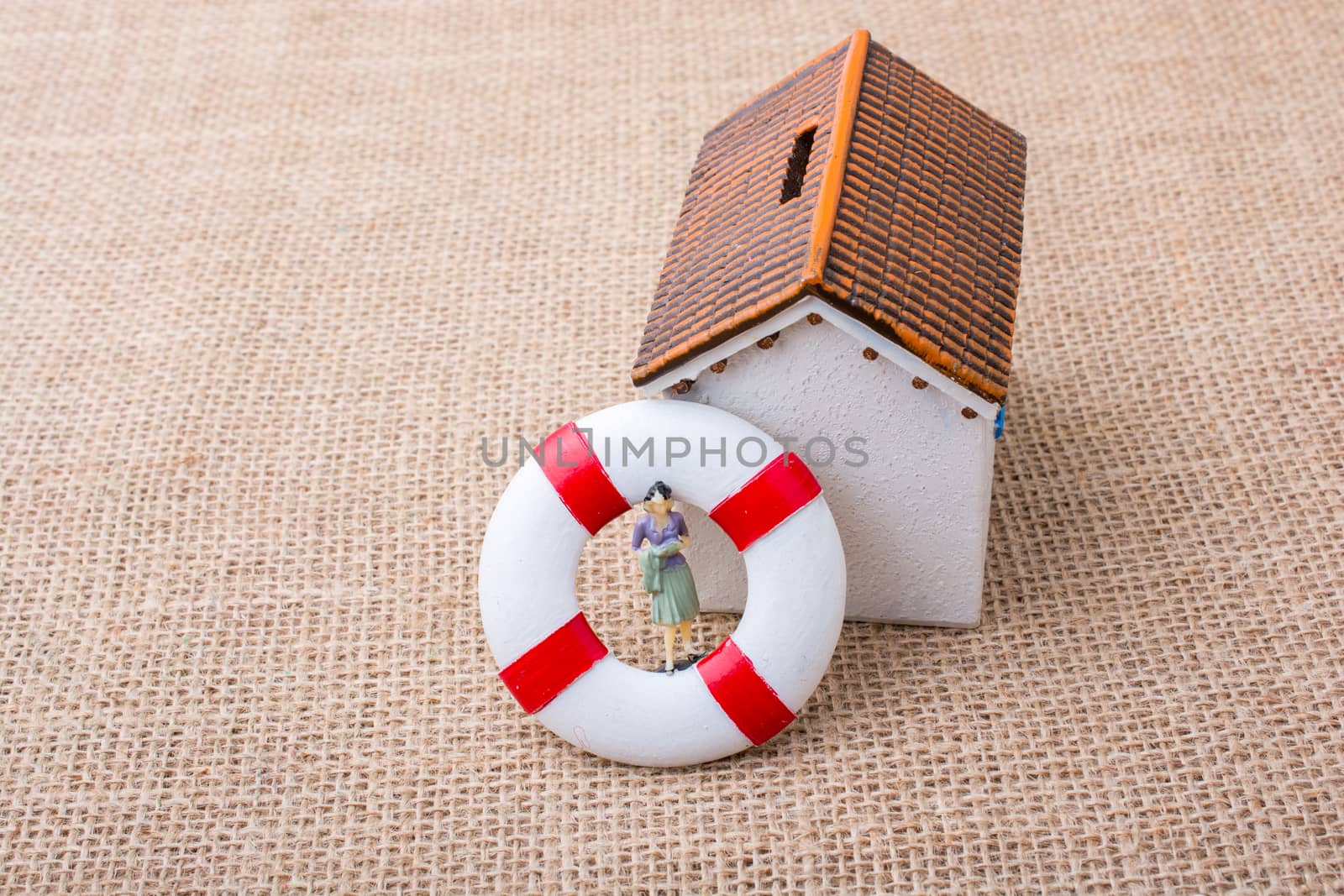 Model house and a life preserver with a woman figure on it
