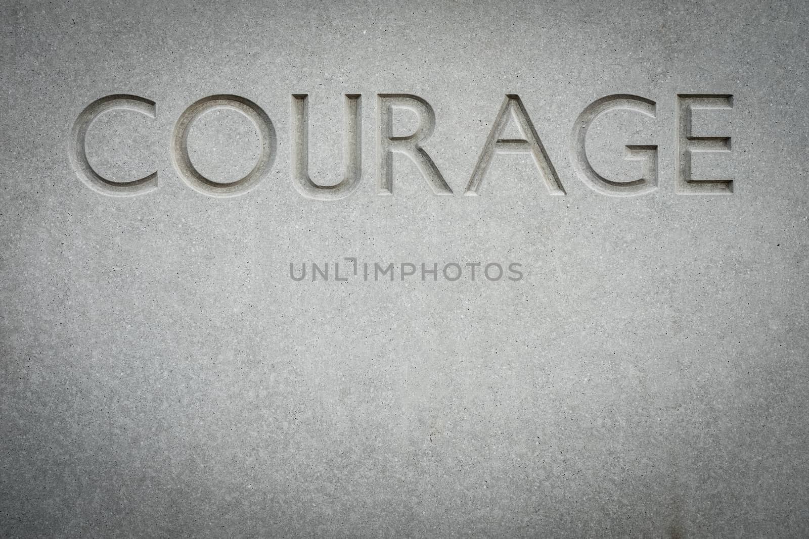 Conceptual Image Of The Word Courage Engraved Into Rock With Copy Space