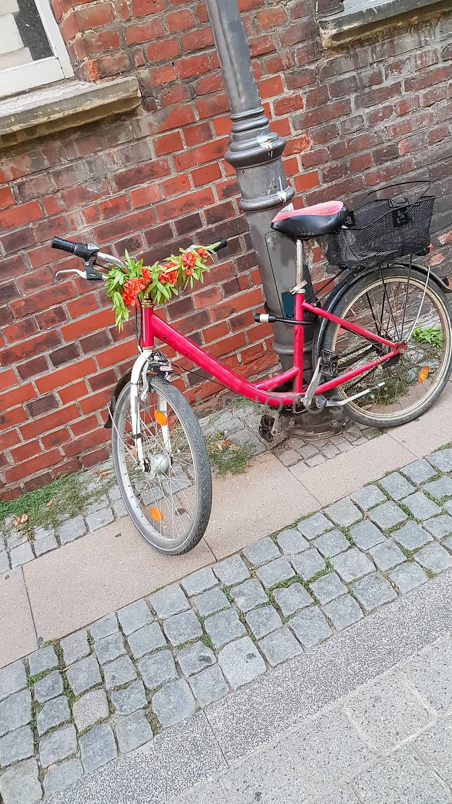 Red bicycle parked in the city at a road sign