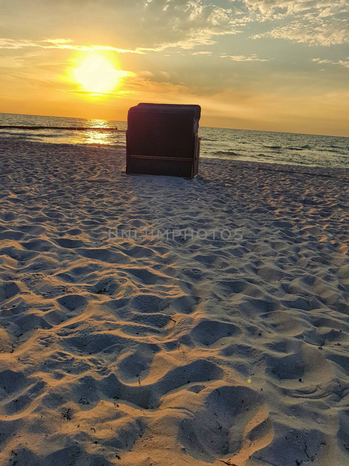 Wicker beach chairs in the romantic morning light at sunrise on the beach