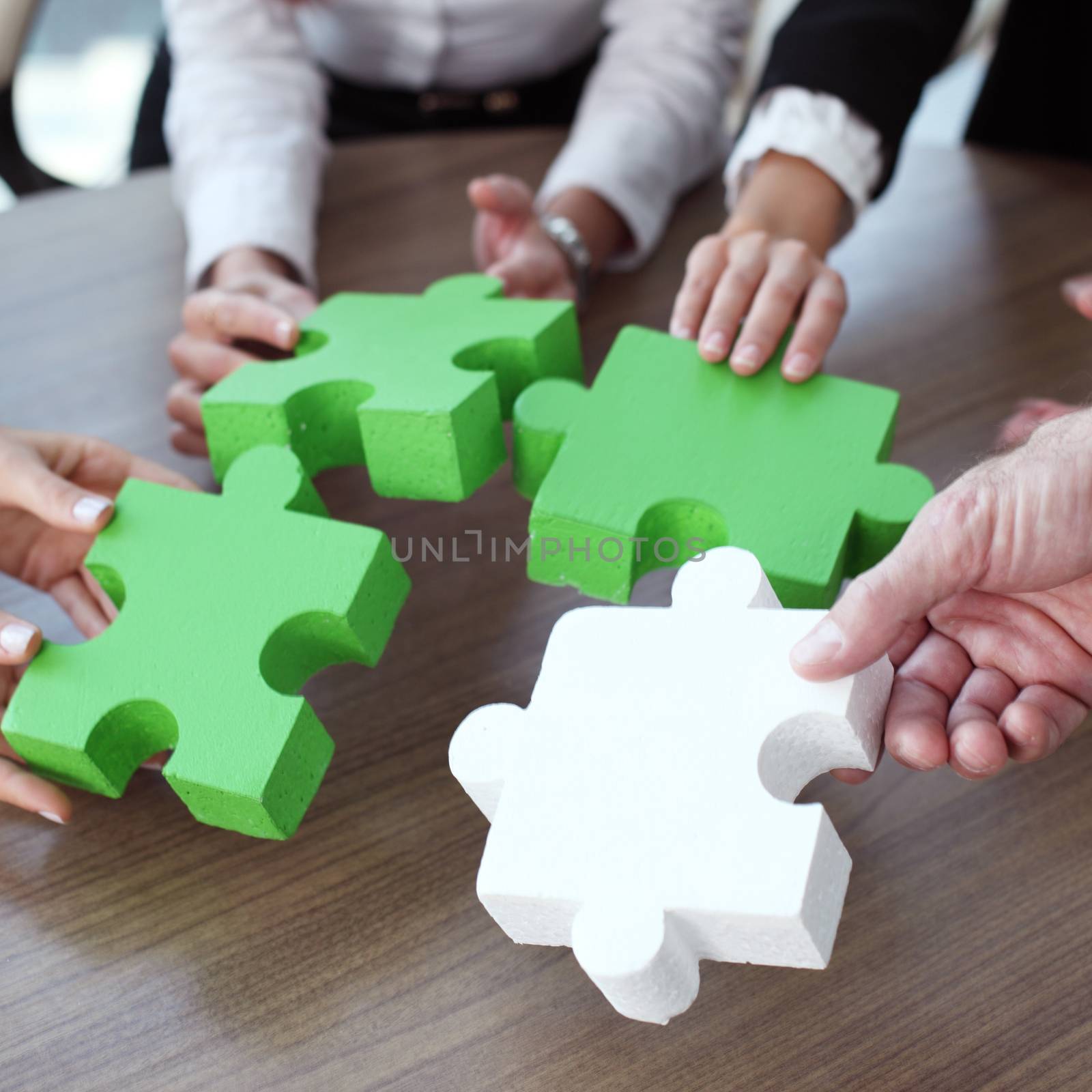Business people assembling puzzle by ALotOfPeople