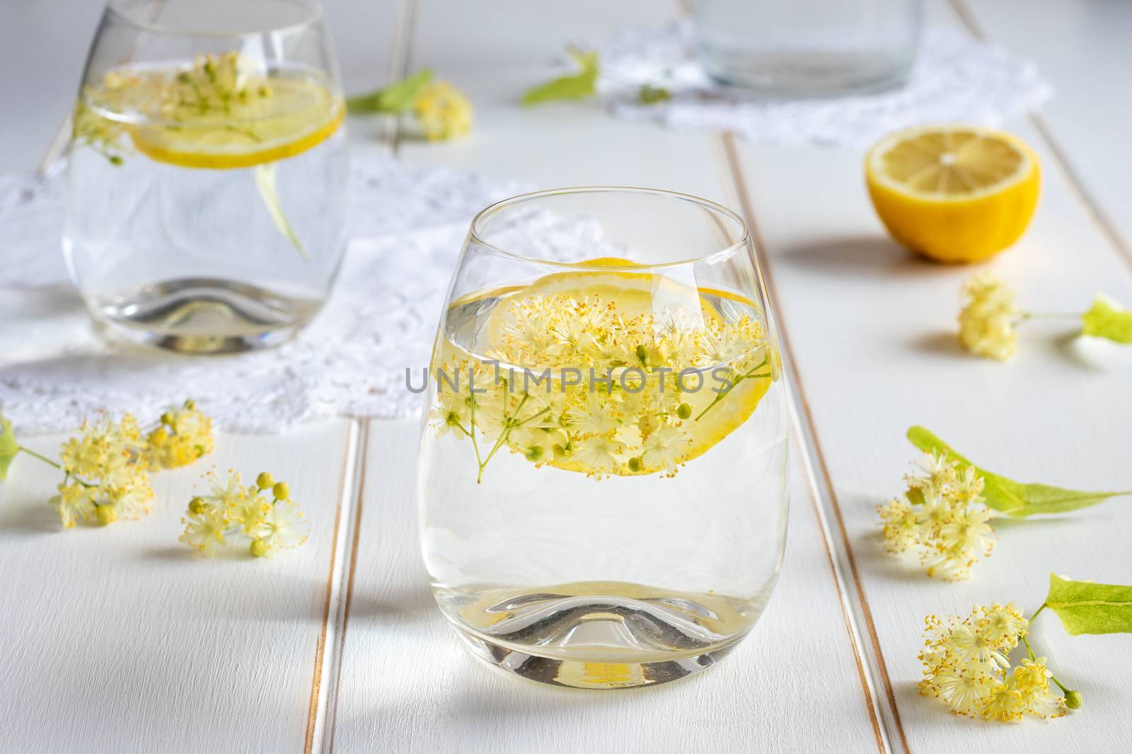 Homemade lemonade with fresh linden flowers on a white table