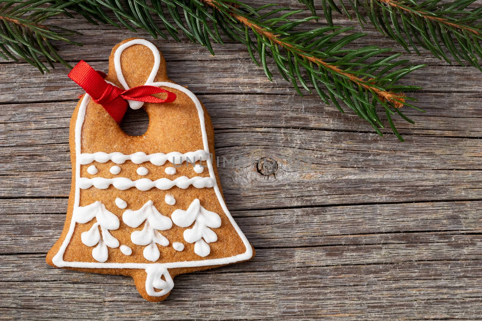 Gingerbread Christmas cookie and spruce branches on a wooden background with copy space