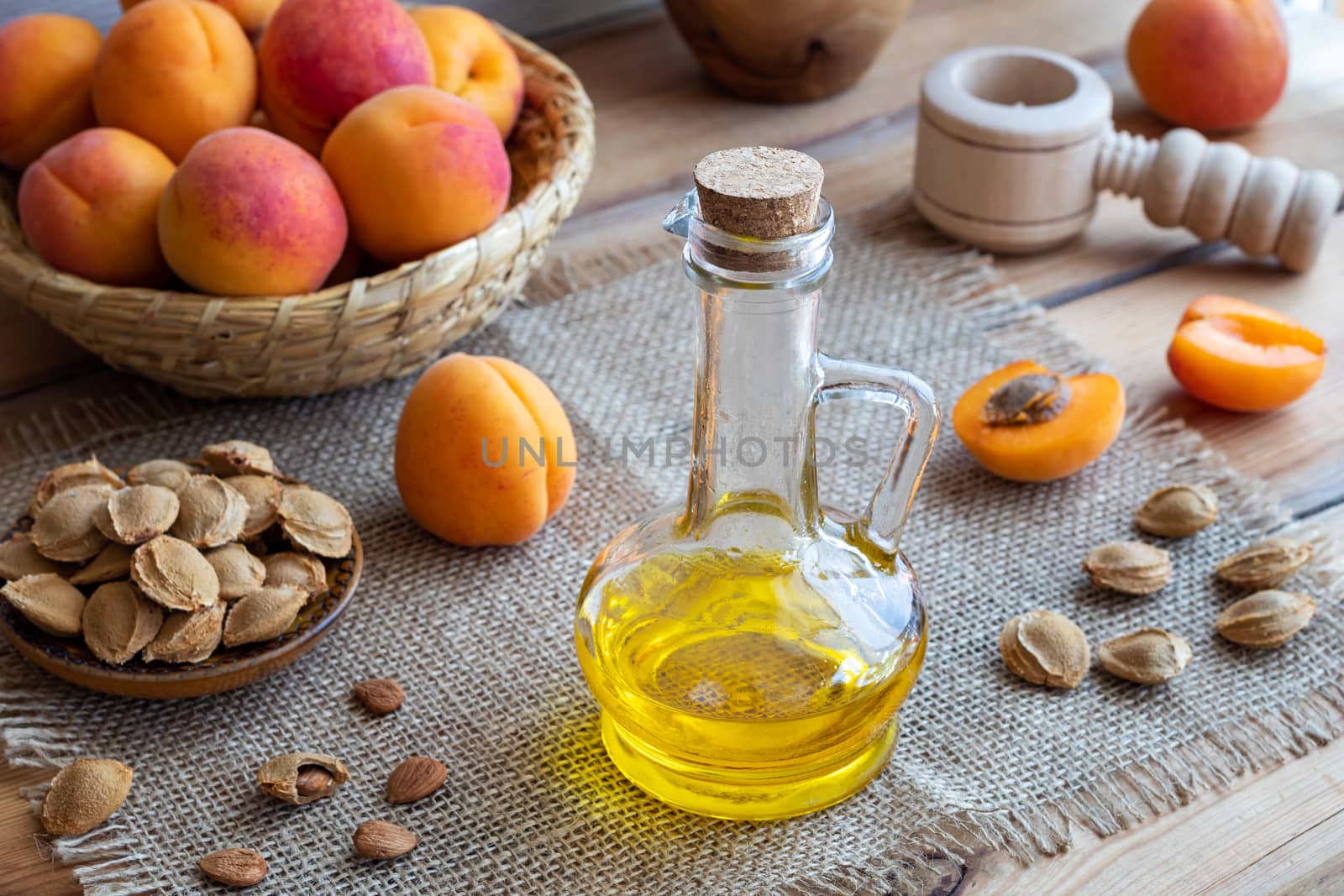 A bottle of apricot kernel oil with fresh ripe fruit