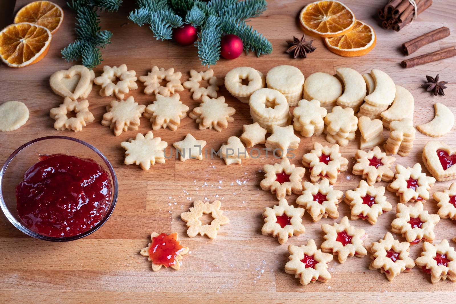 Filling traditional Linzer Christmas cookies with strawberry jam