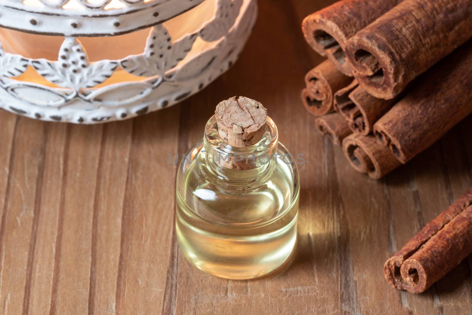 A bottle of essential oil with cinnamon sticks