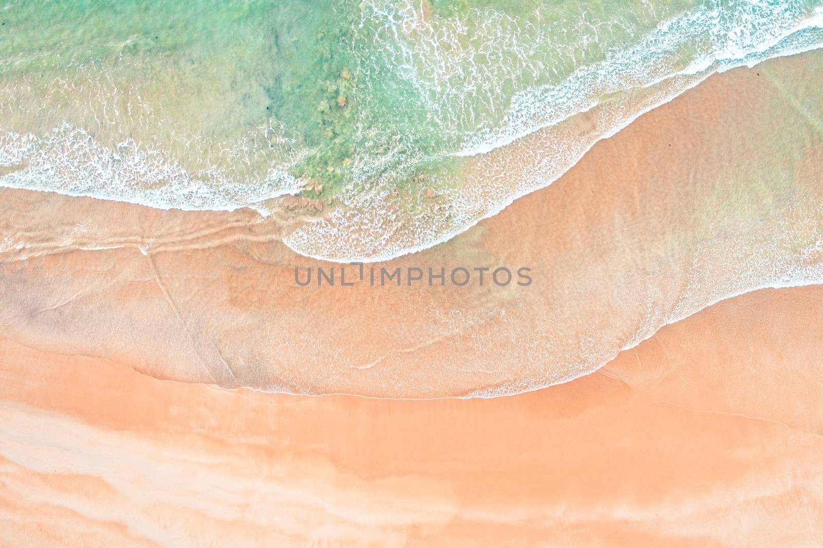 Aerial shot of waves and sand patterns on a beach in Sydney Australia