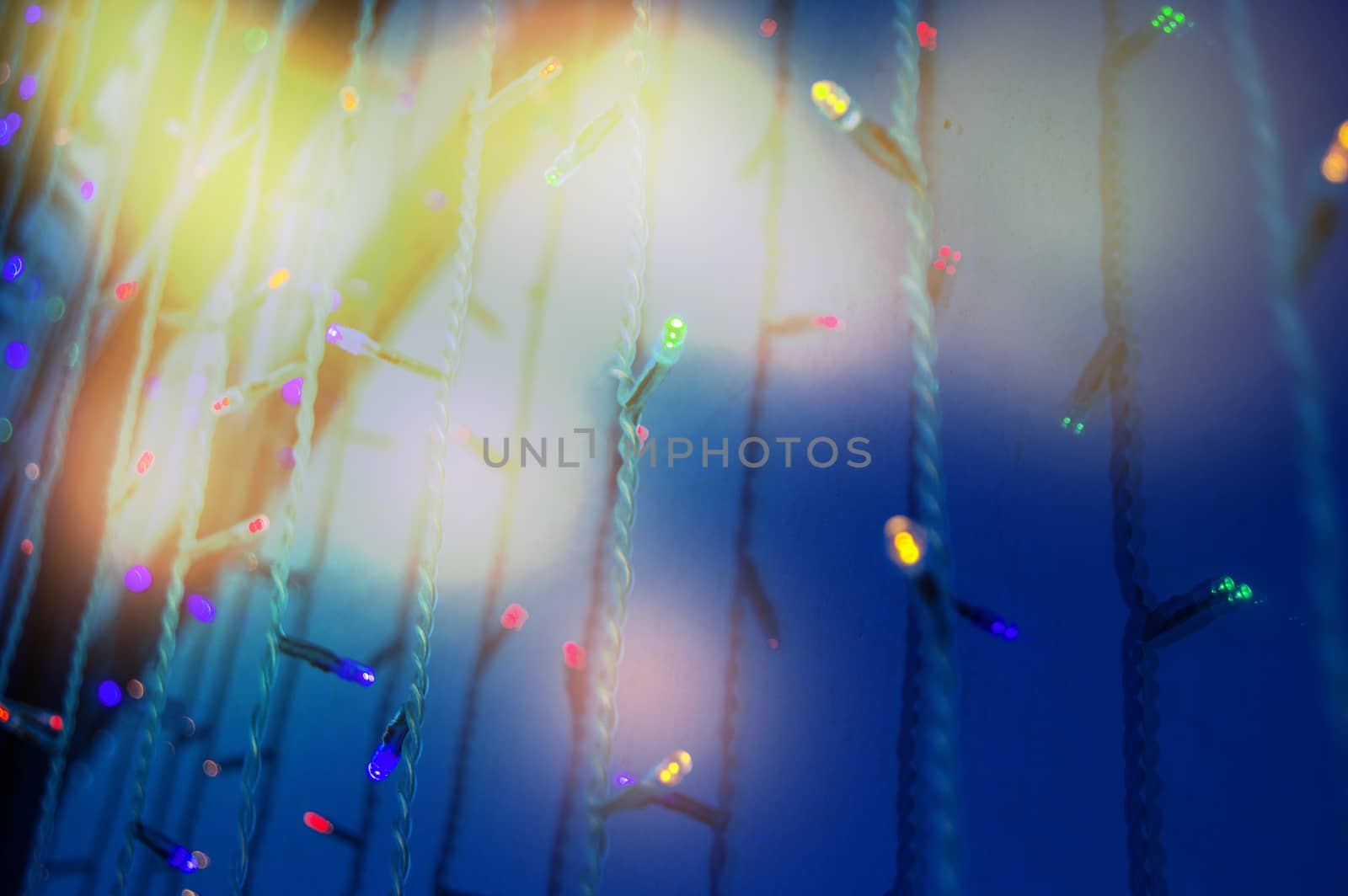 Modern glass wall of the building with festive illumination led lamps and bright highlights.