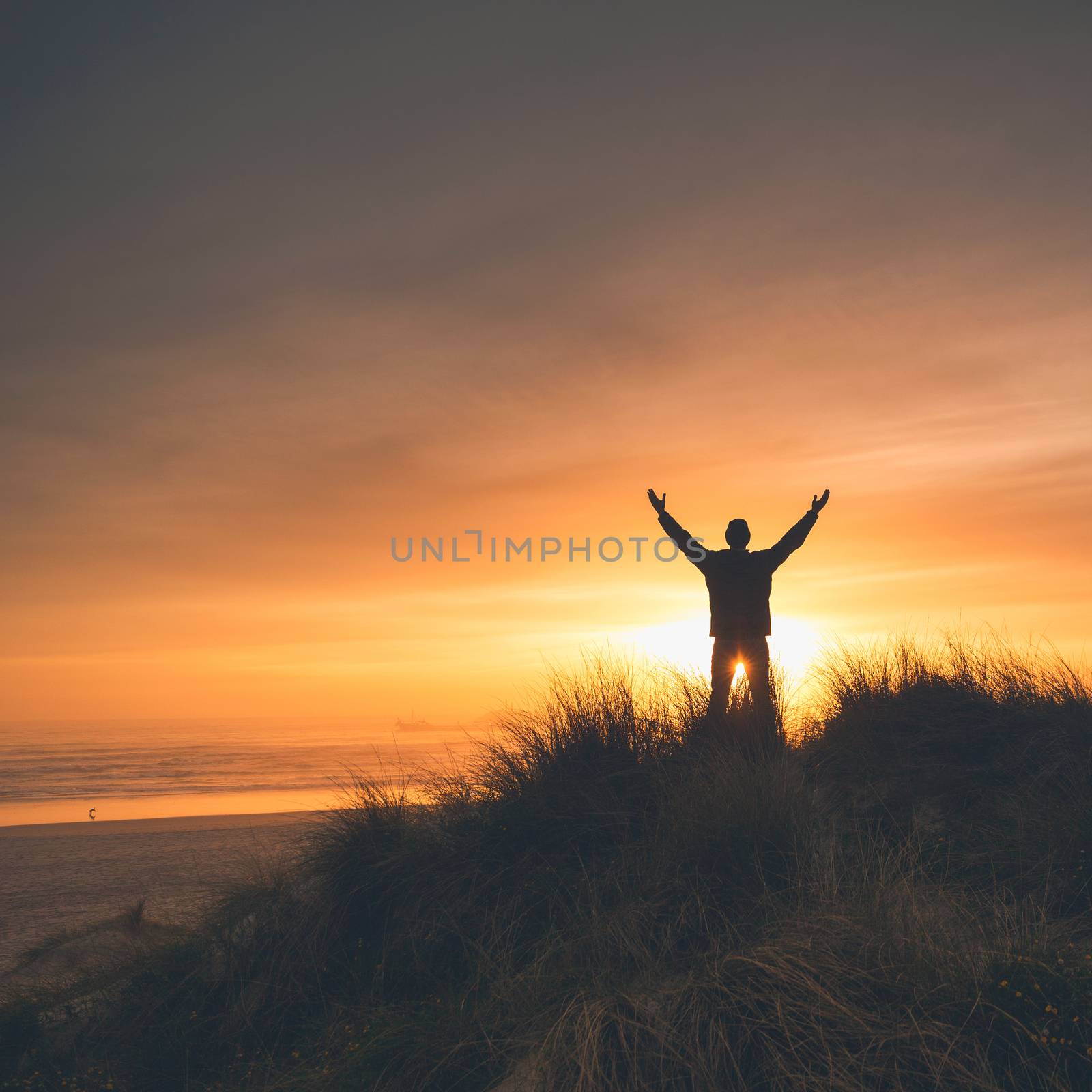 Man on the sand dunes at the sunset