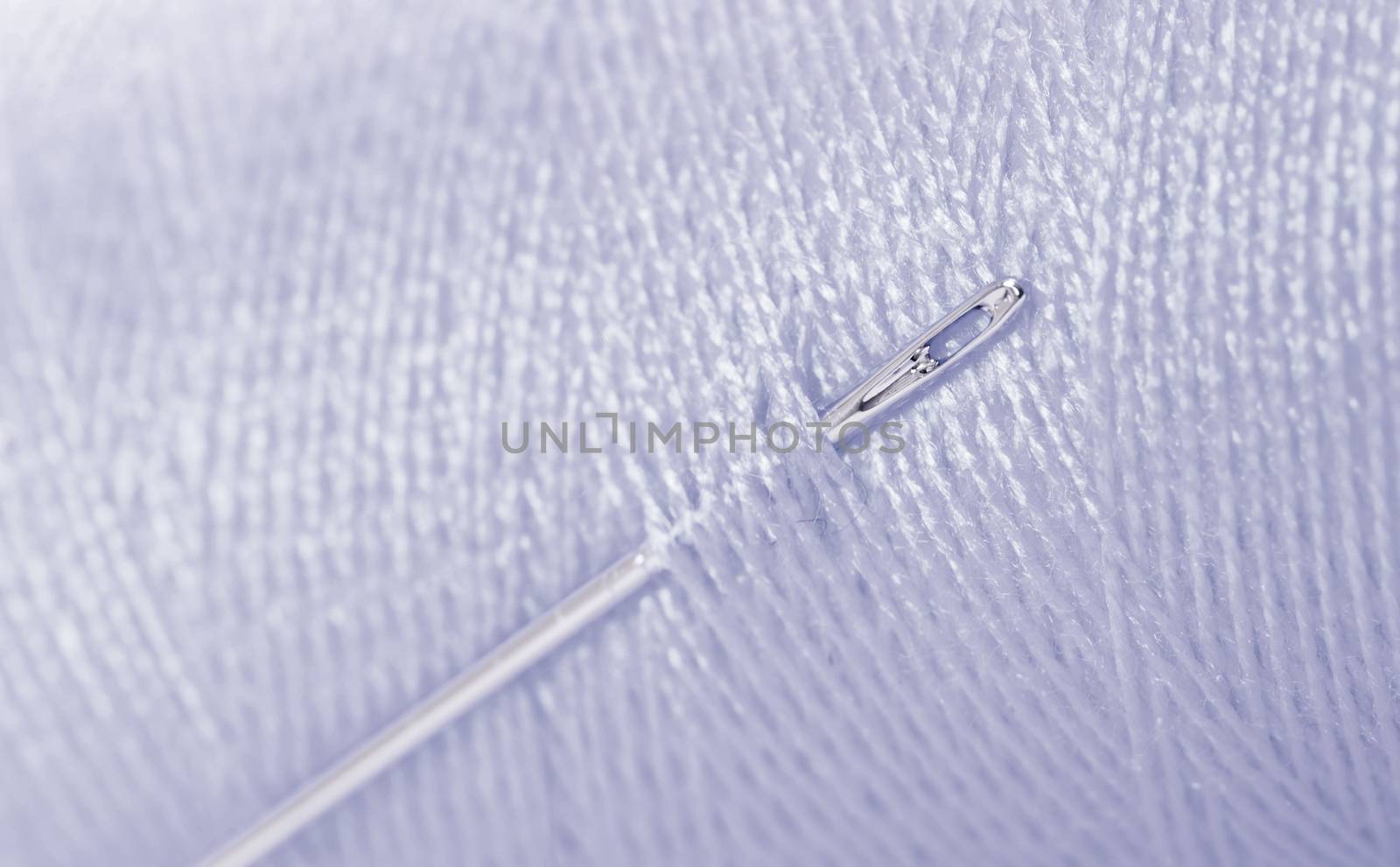 Grey threat with needle, full frame, focus on needle