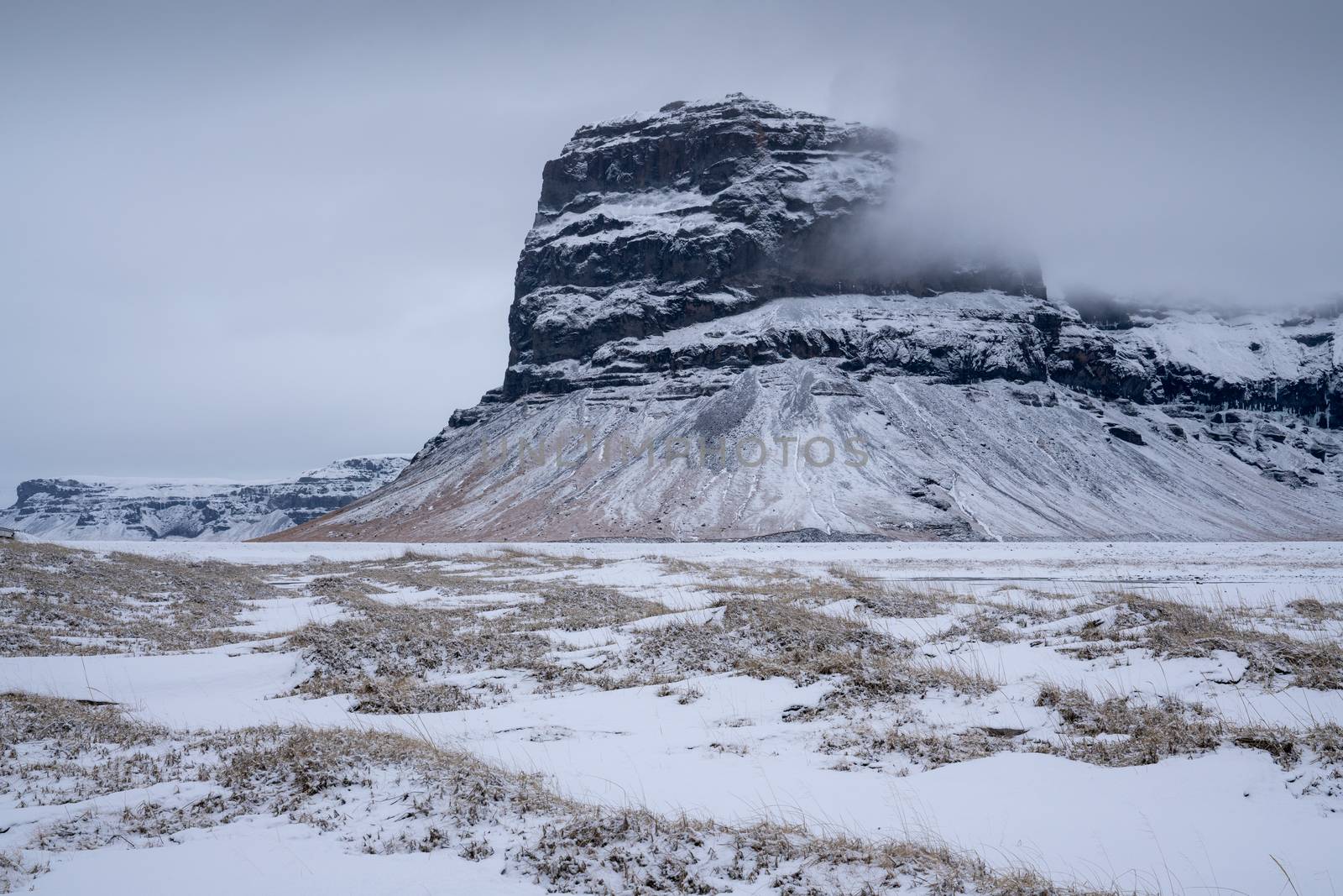 Panoramic landscape along the southern coast of Iceland with snow-covered mountains 