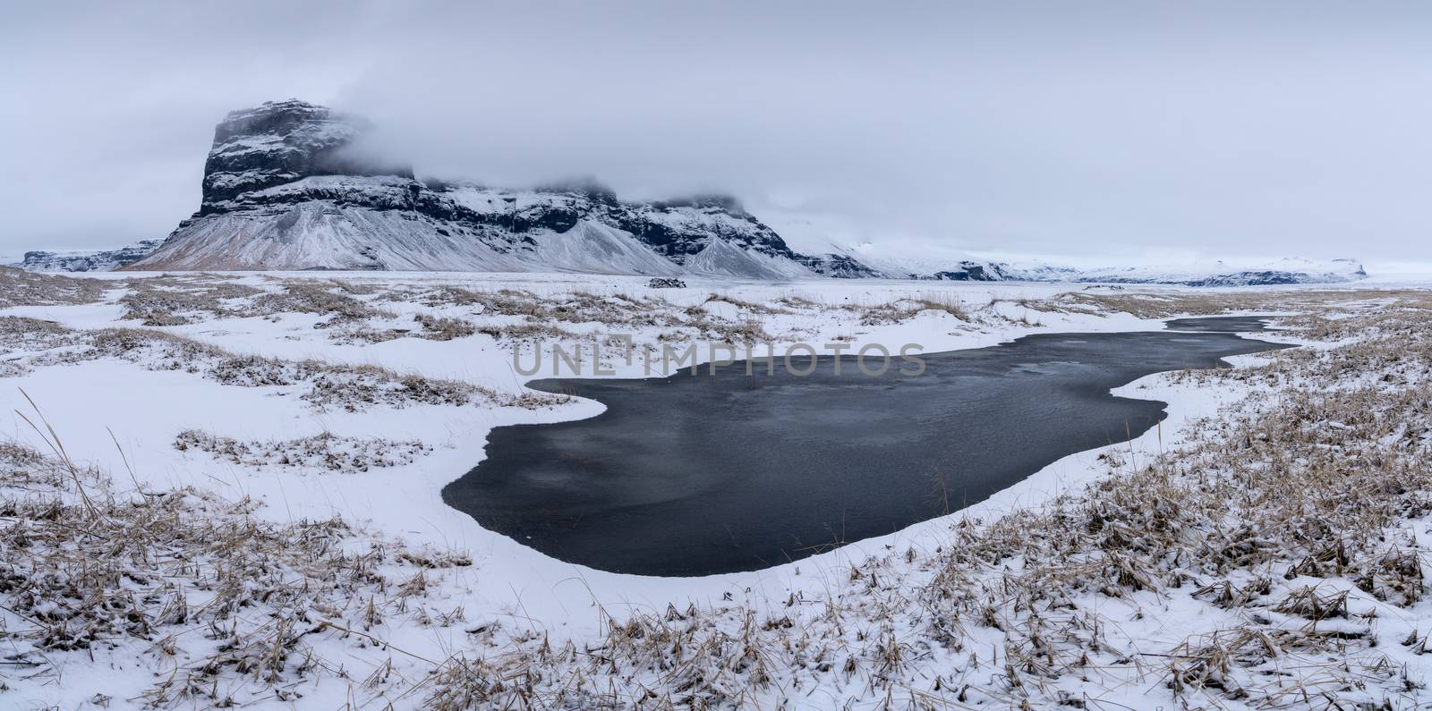 Panoramic landscape along the southern coast of Iceland with snow-covered mountains 