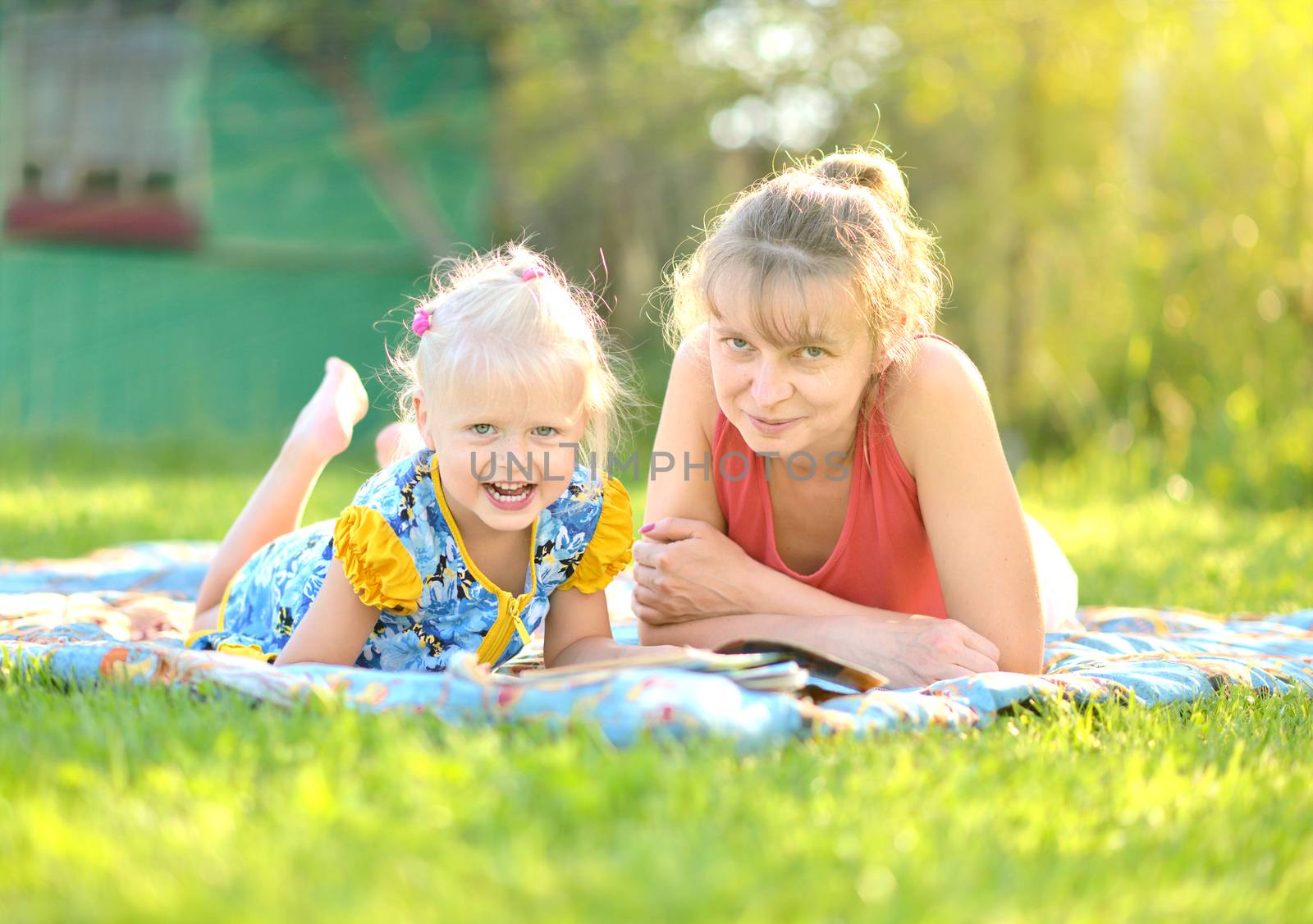 mother and daughter have a rest on nature on green grass