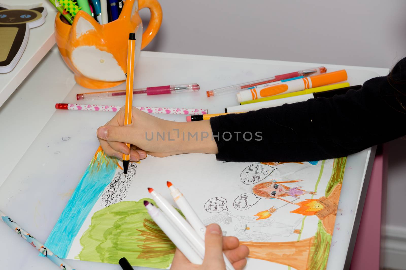 Girl drawing a picture for the school on the instructions of the teacher