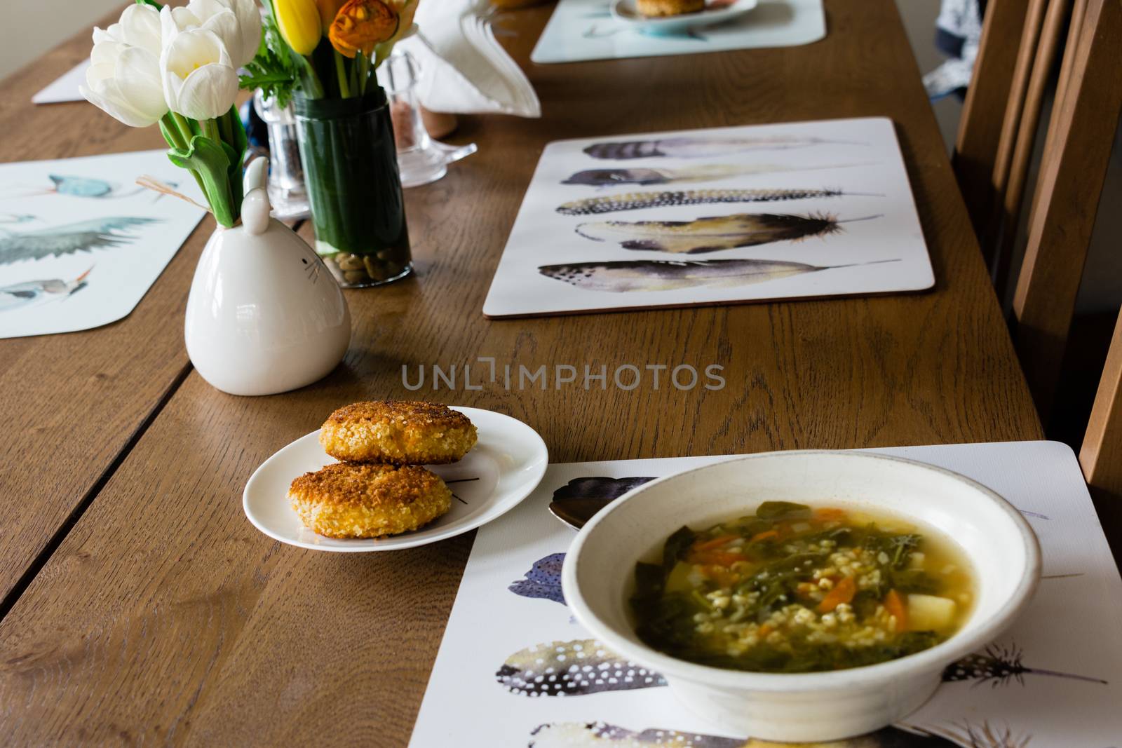 Two cutlets and a plate of soup on the dinner table by ben44