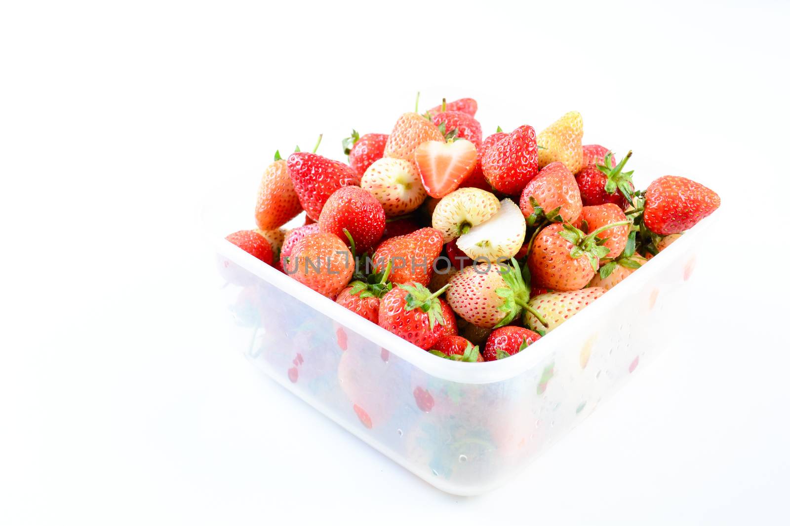 Fresh strawberries in white transparant box on white background