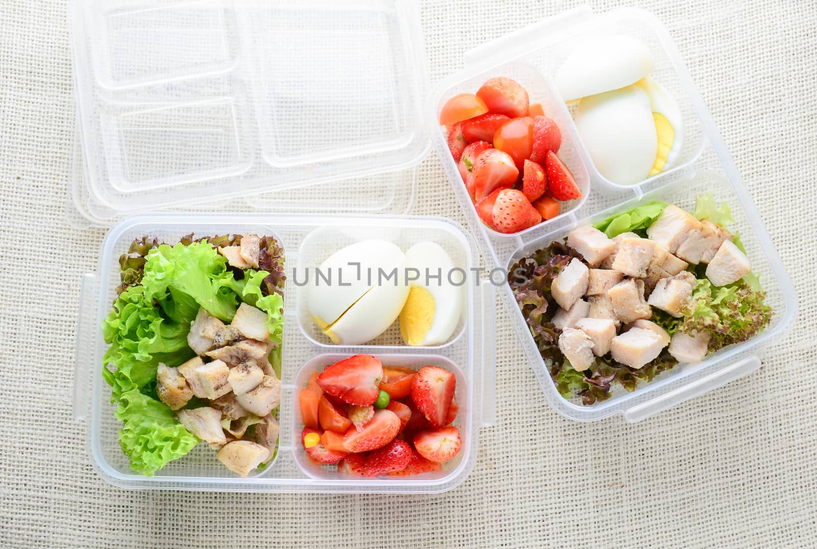 Modern style clean food, boiled egg, grilled chicken and avocado, strawberry, vegetable salad
