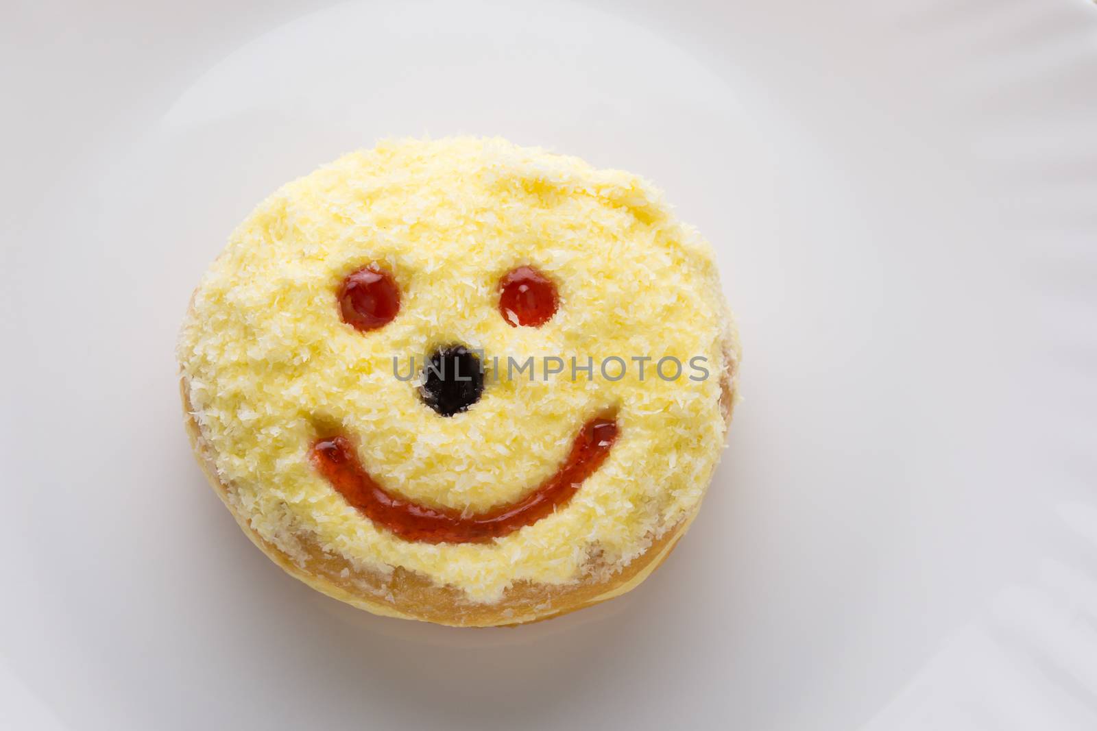 Smiley donut on a white plate, donut with white background  
