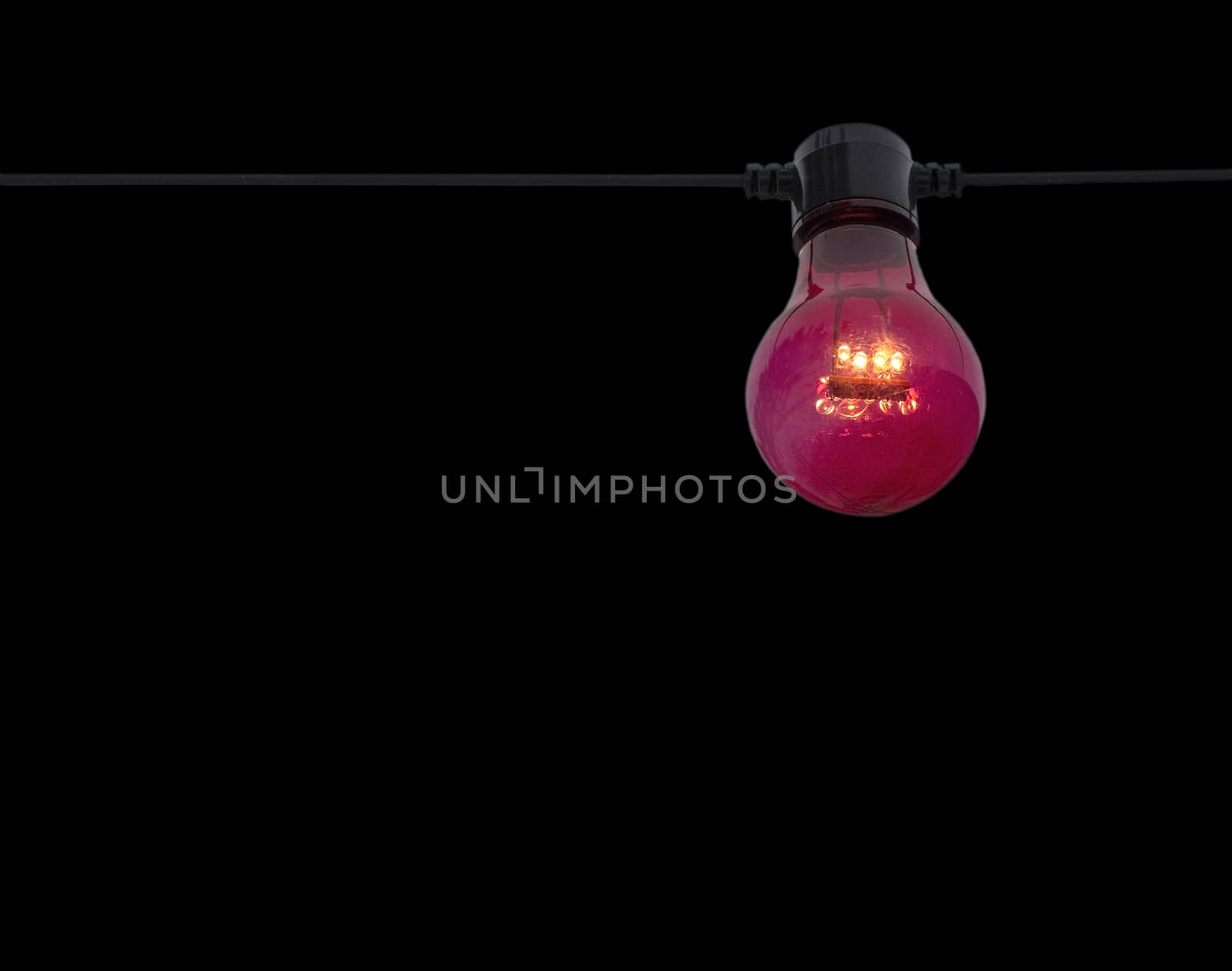 Red color lightbulb on string isolated on black