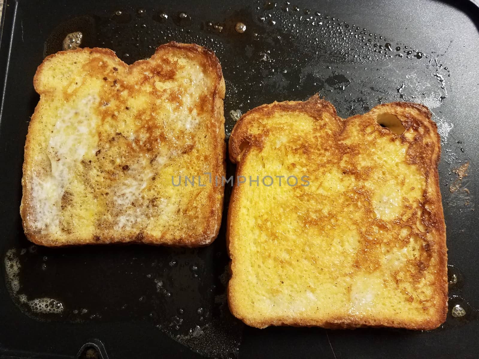 French toast bread with egg and cinnamon cooking on grill by stockphotofan1