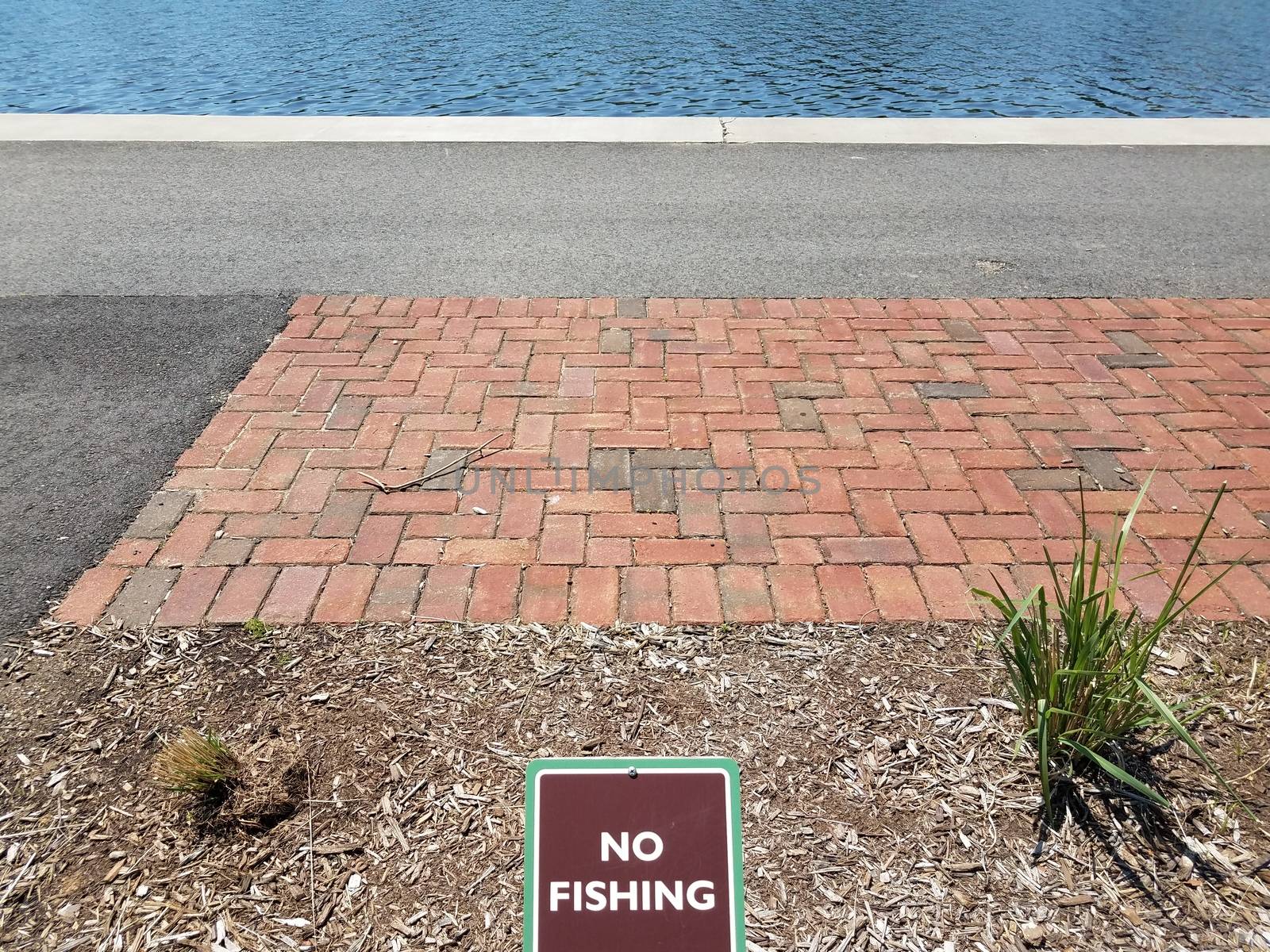 brown no fishing sign with red bricks and water and asphalt by stockphotofan1