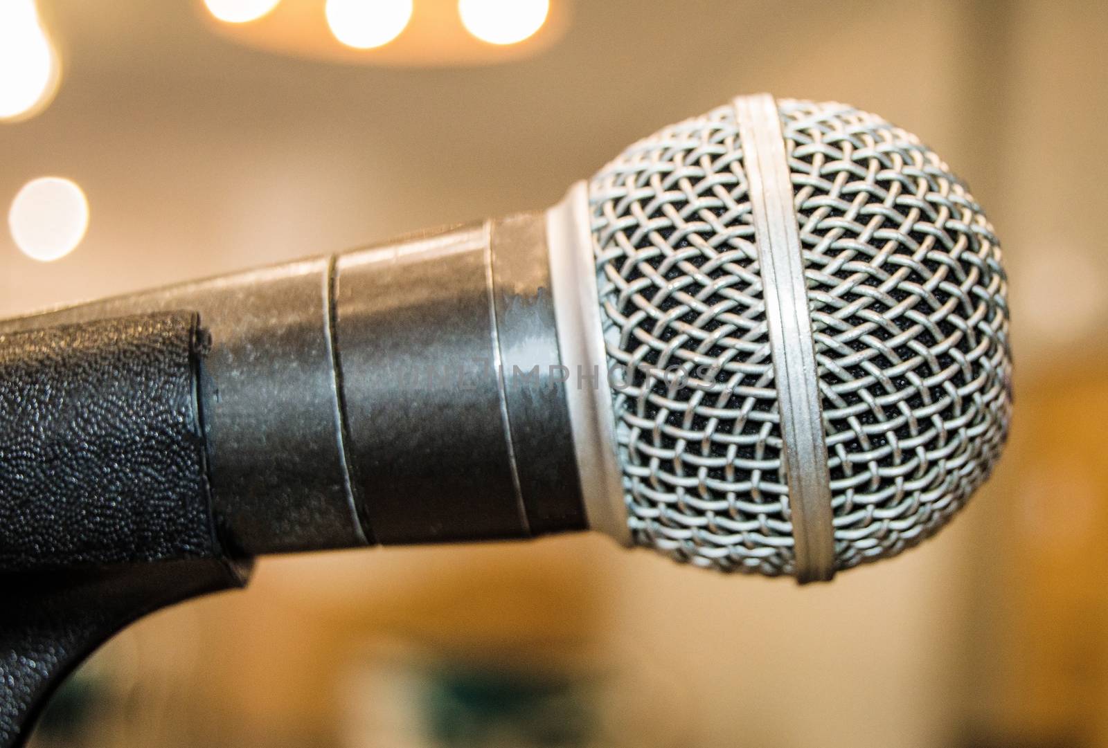 Microphone close-up, used by speaker to speak in conference room, seminar, University, lectures, blurred background.