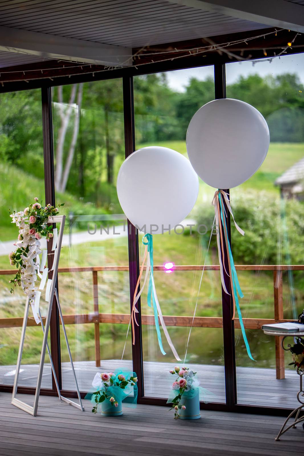 Luxury decorated place for wedding reception in restaurant. Wedding place in restaurant decorated with balloons, ribbons and flowers.
