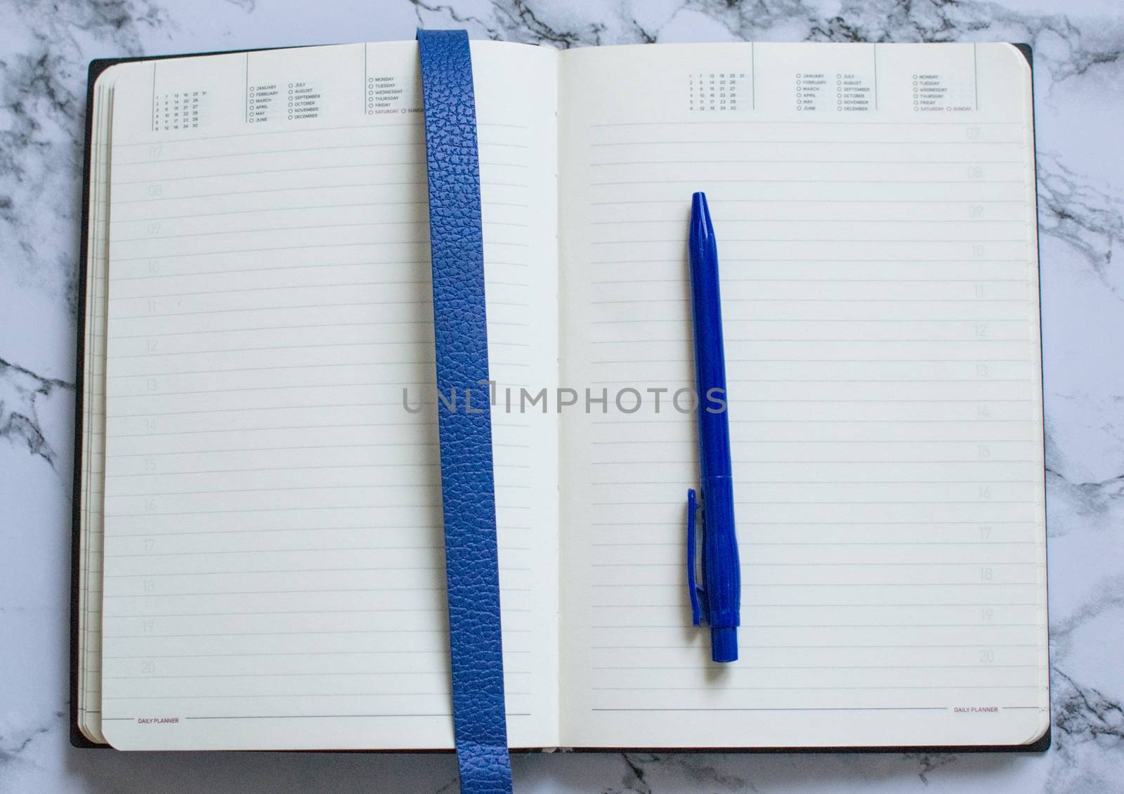 Blank page open planner with blue pen on marble background