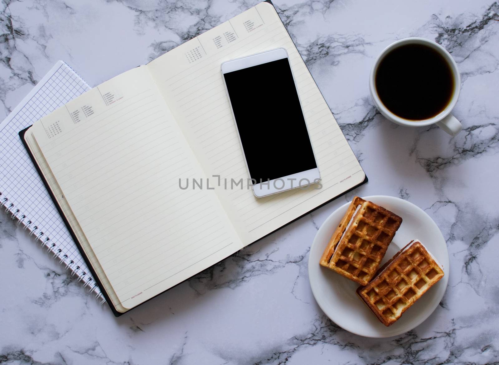 two planners on marble background, coffee, waffles and smartphone - buisness lunch