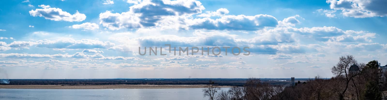 View of the Amur river against the blue sky with white beautiful clouds. Bright spring sun. Russia, Khabarovsk. by rdv27