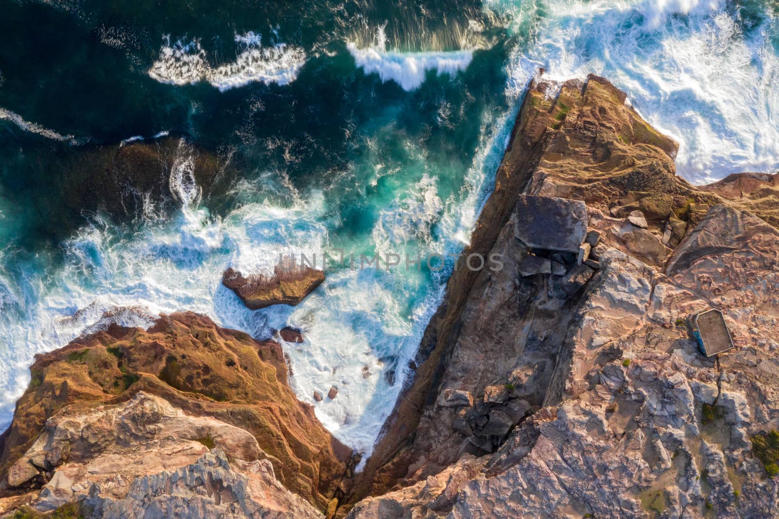 The rocky coastline of East Sydney where the cliffs have broken off in large chunks and waves continually batter the exposed lower areas wearing them down bit by bit.