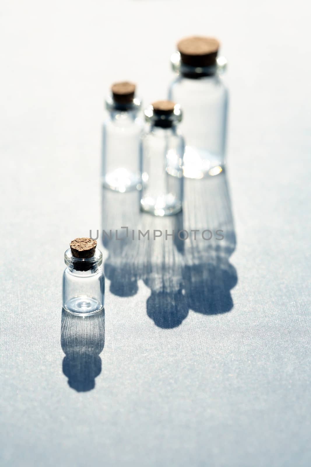 Set of small bottles with long shadow on white background