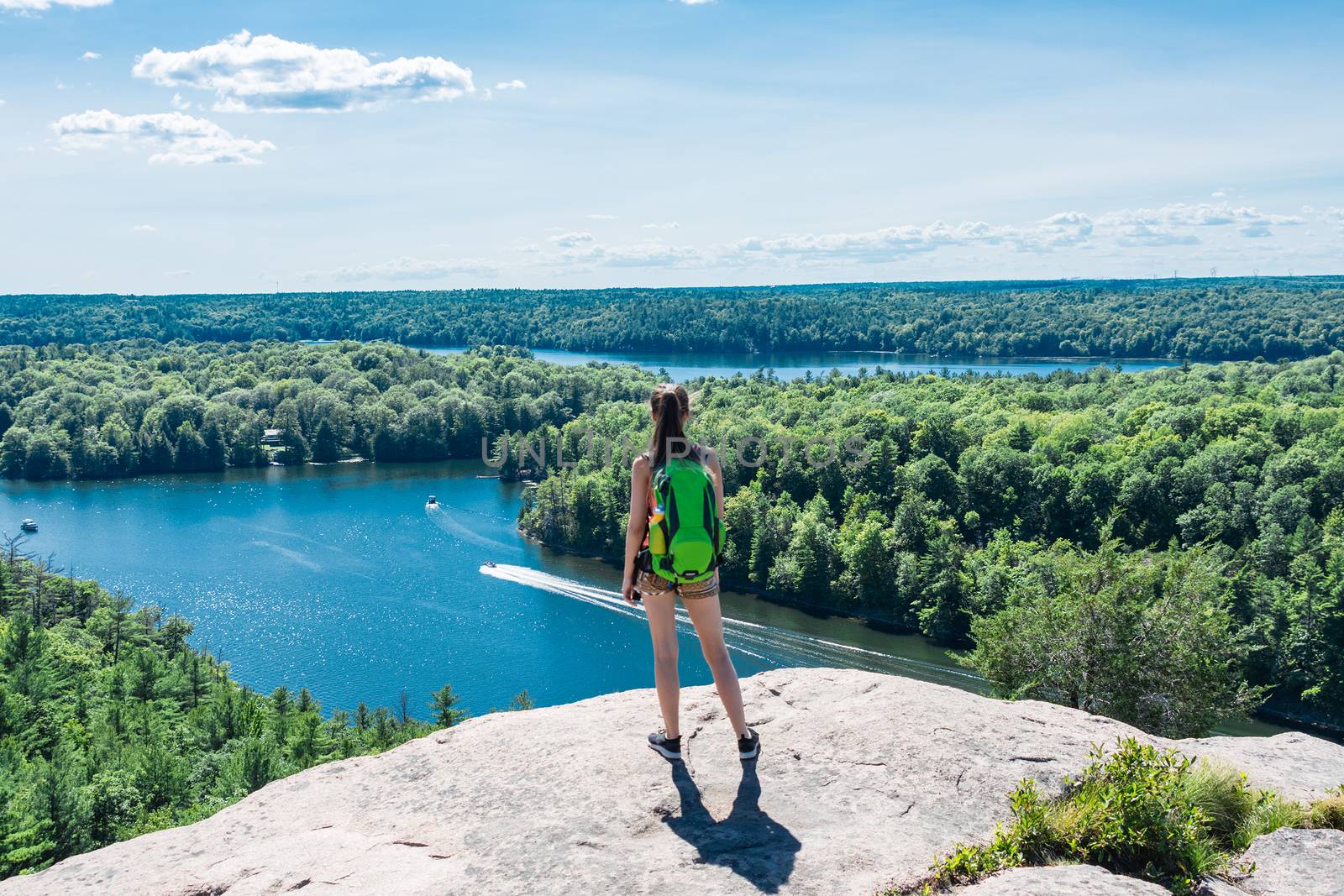 A girl on top of a mountain near a large lakes by ben44