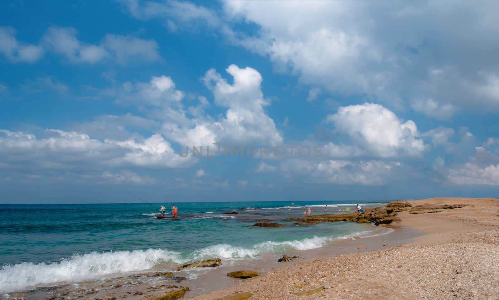 On a fine day, the fishermen under the white clouds rest on a wild, sea beach