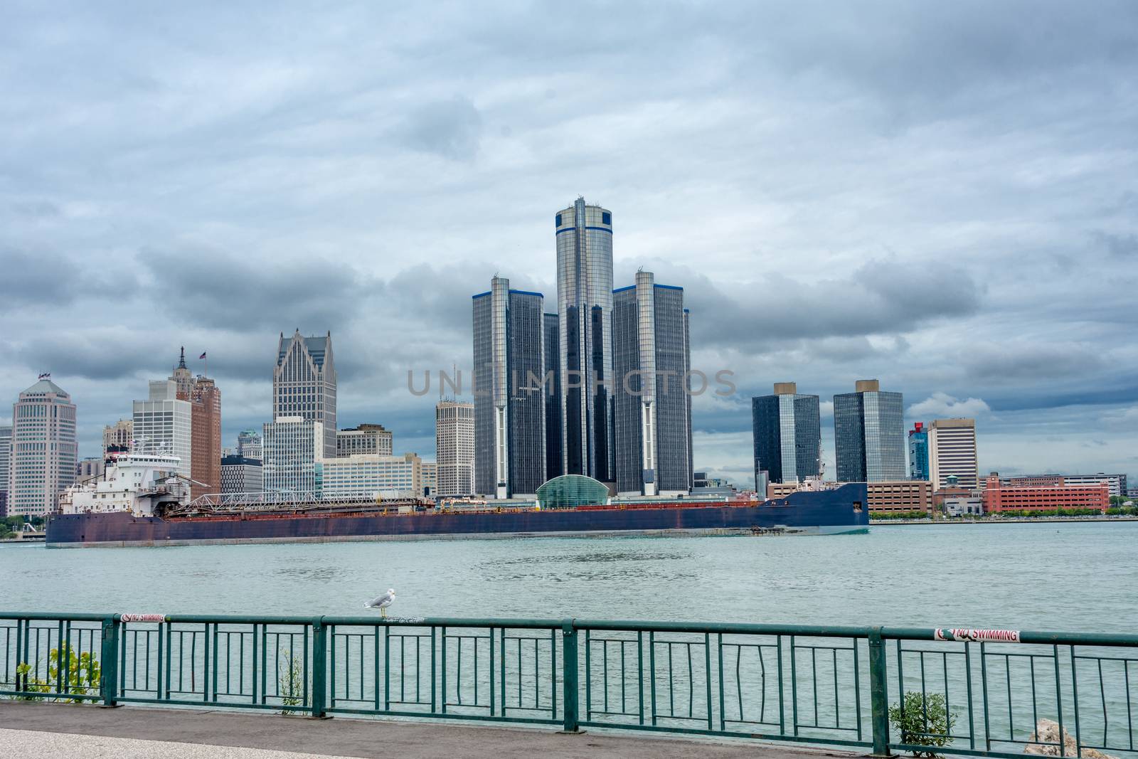 Panorama with high-rise buildings of GM against the sky from gray clouds with a barge floating on the river