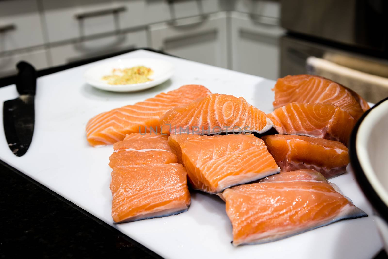 Pieces of sliced salmon fillet lie on a white sheet by ben44