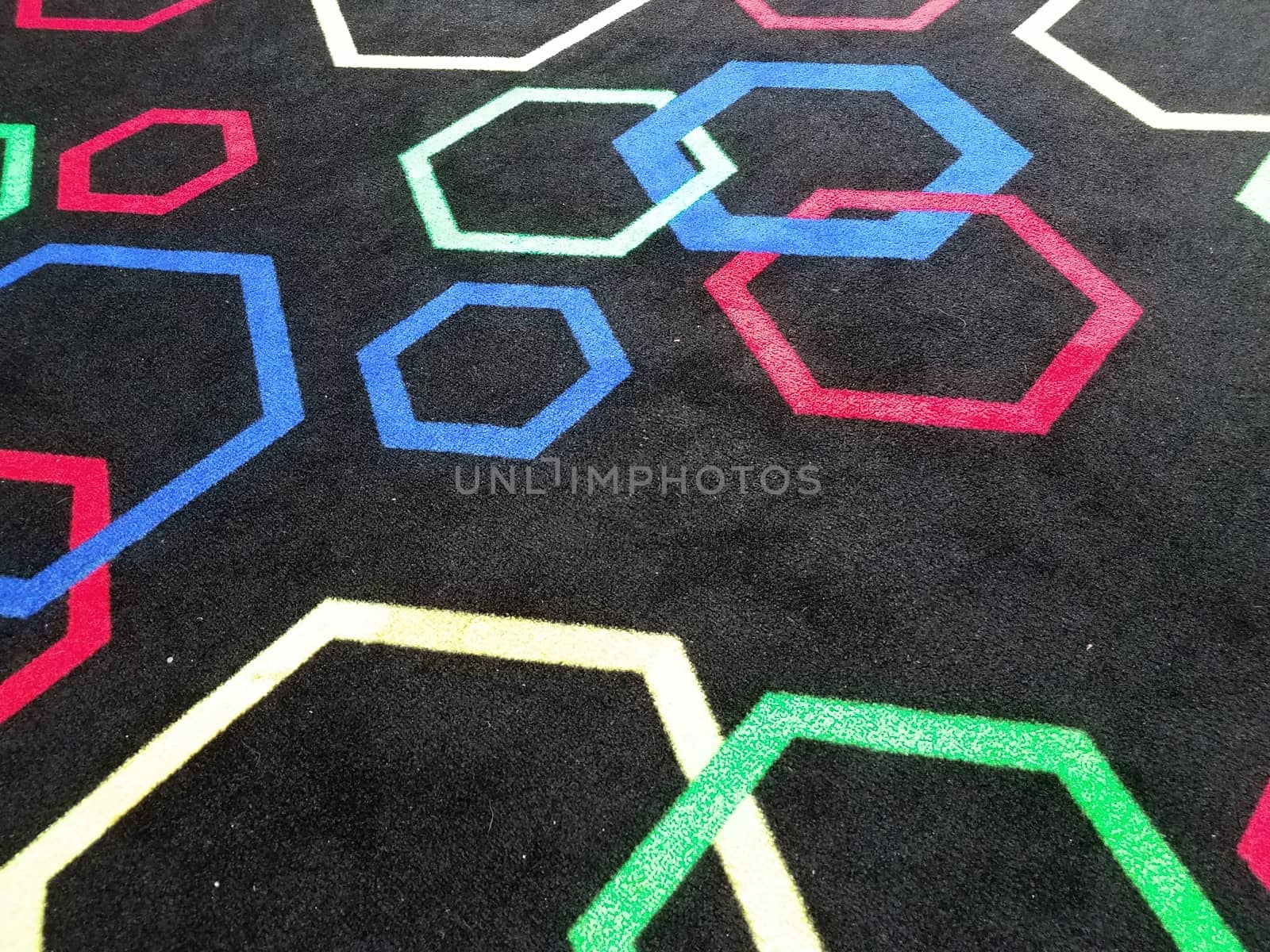 black carpet or rug with colorful hexagon shapes by stockphotofan1