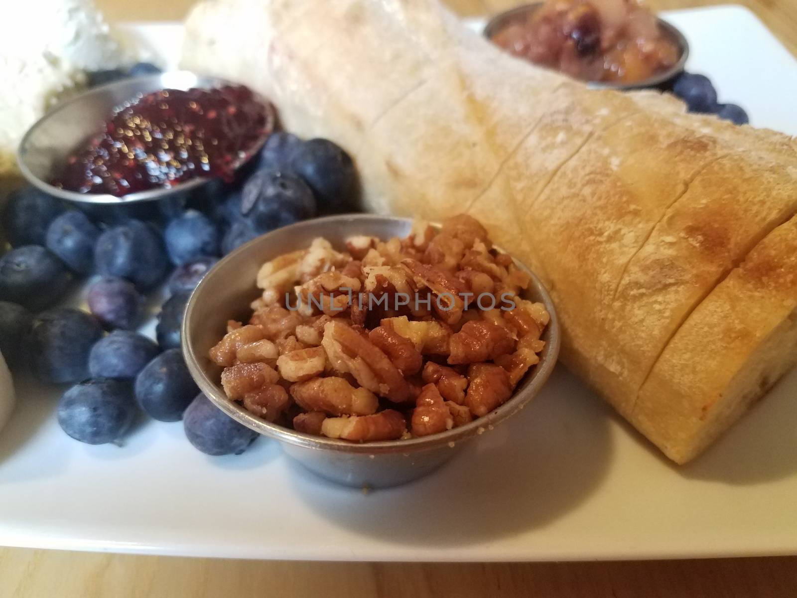 pecans and bread and blueberries on white plate by stockphotofan1